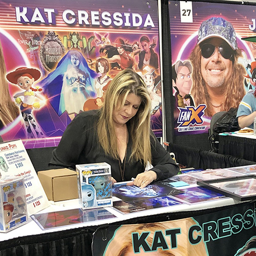 Kat Cressida autographs a poster